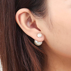 White double sided pearl earrings worn by the model showing smaller pearl to the front   | Orchira