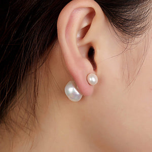 White double sided pearl earrings worn by the model, smaller pearl to the front | Orchira